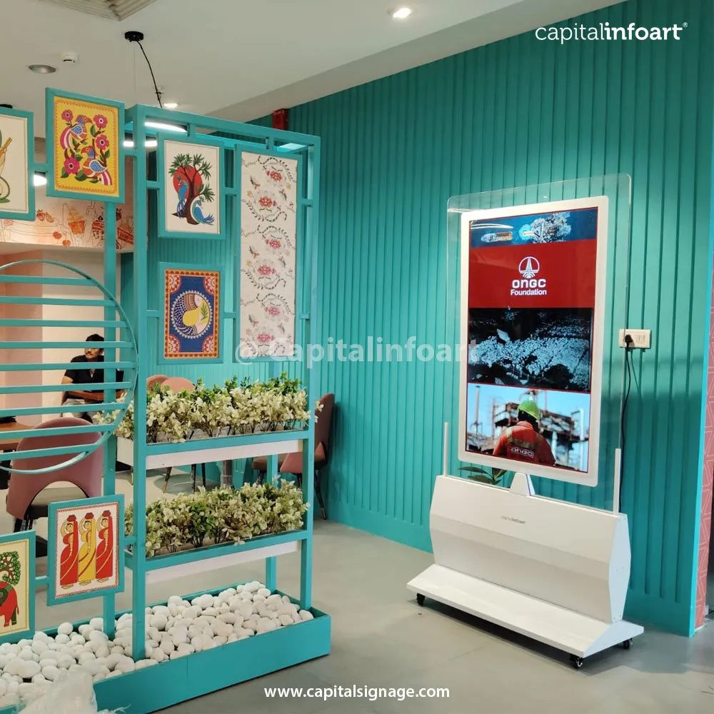 Premium glass kiosk showing ONGC content against a teal wall