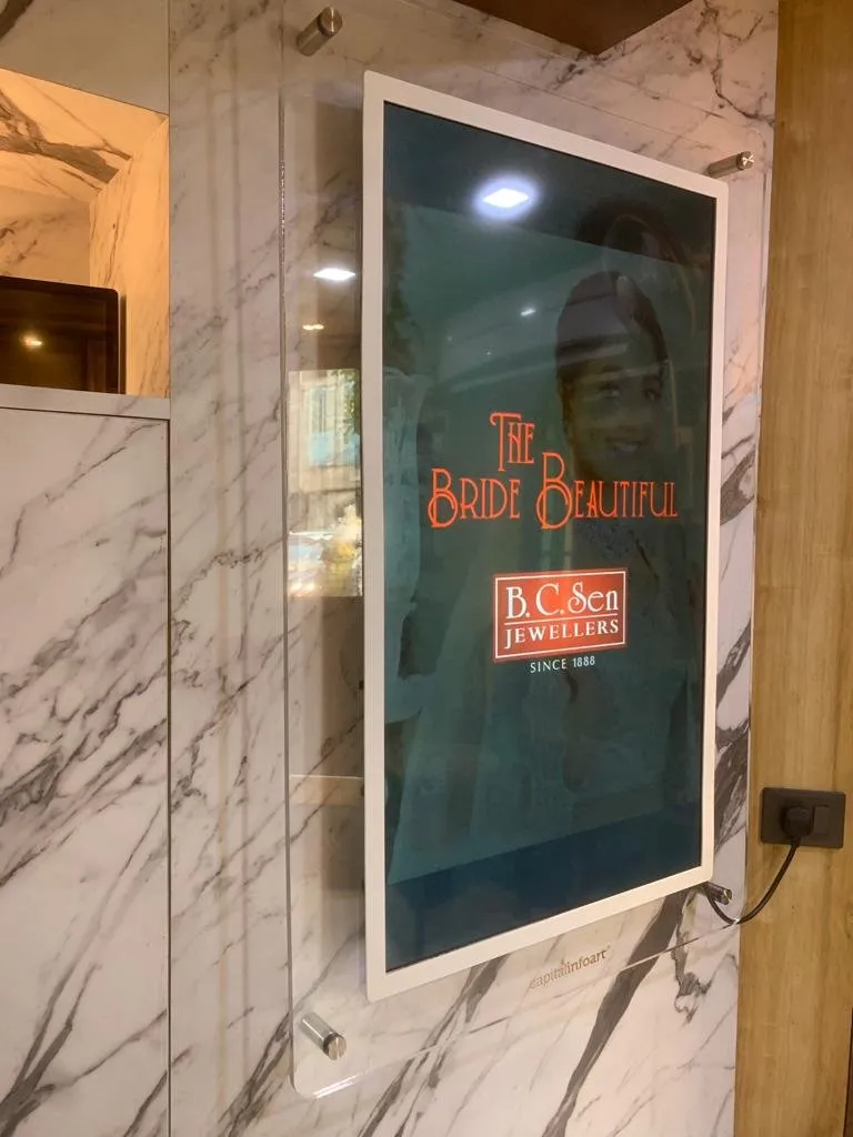 Premium Glass Signage mounted on a marble wall at a bridal store
