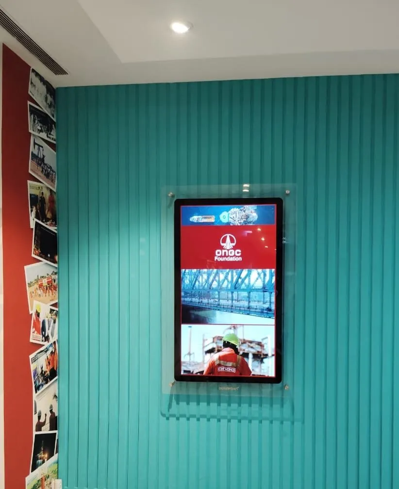Premium Glass Signage on a teal ribbed wall showing ONGC content