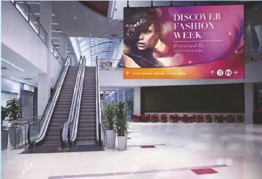 Indoor LED wall above an escalator in a shopping mall atrium